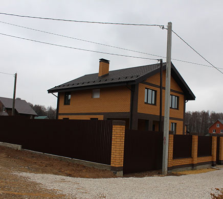 Фотография дома с крышей из металлочерепицы Велюр тёмного цвета