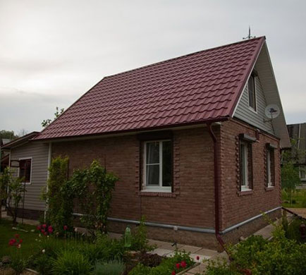 Фото небольшого дома с металлочерепицей Квинта Плюс с оттенком красного цвета